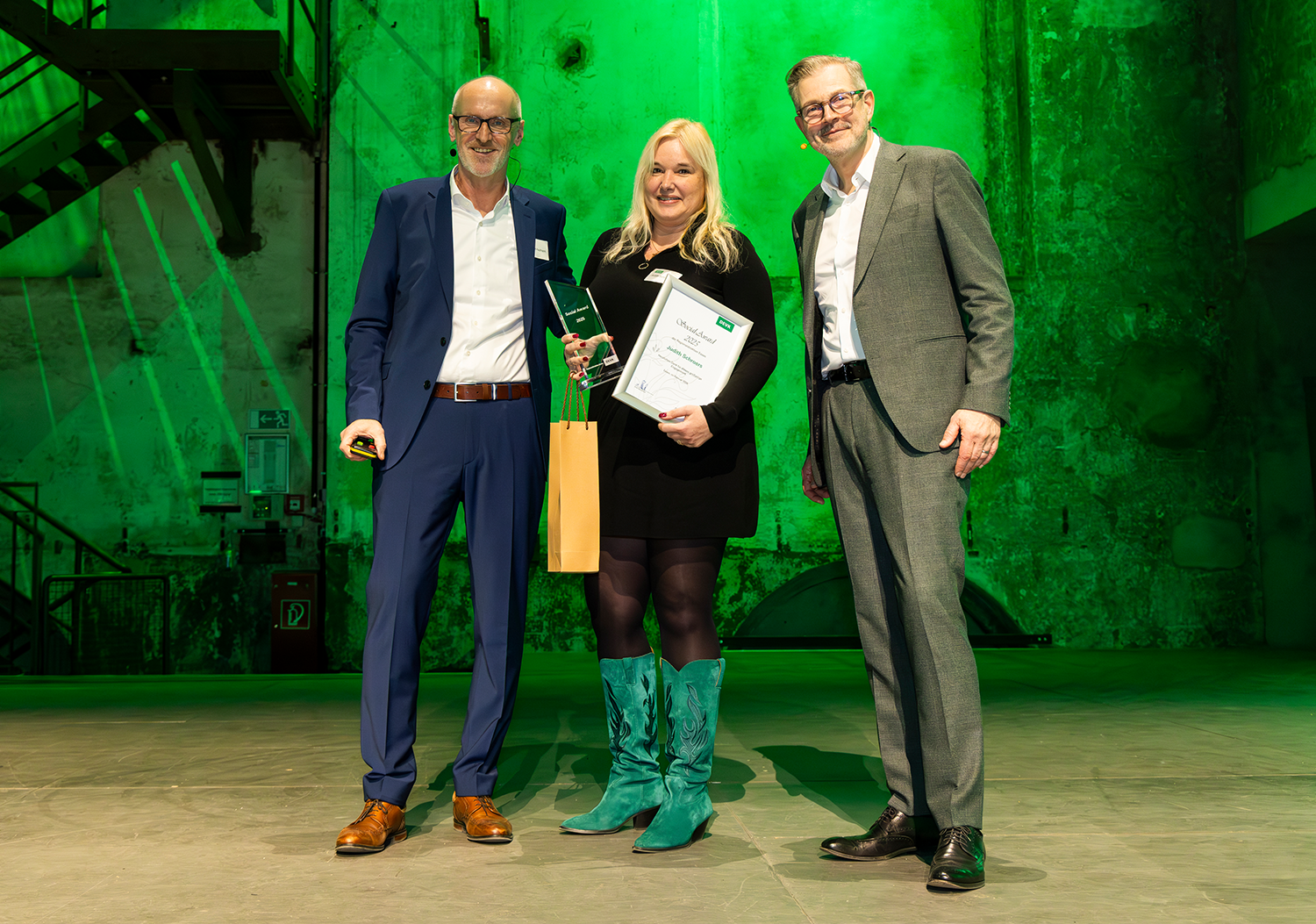 Judith Schroers wird auf der Jahresauftakttagung der DEVK‑Regionaldirektion Essen im Februar 2026 von Steffen Kaufmann, Geschäftsleiter Innendienst, und Axel Berberich, Geschäftsleiter Außendienst, mit dem Social Award geehrt. (v. l. n. r.: Steffen Kaufmann, Judith Schroers, Axel Berberich)