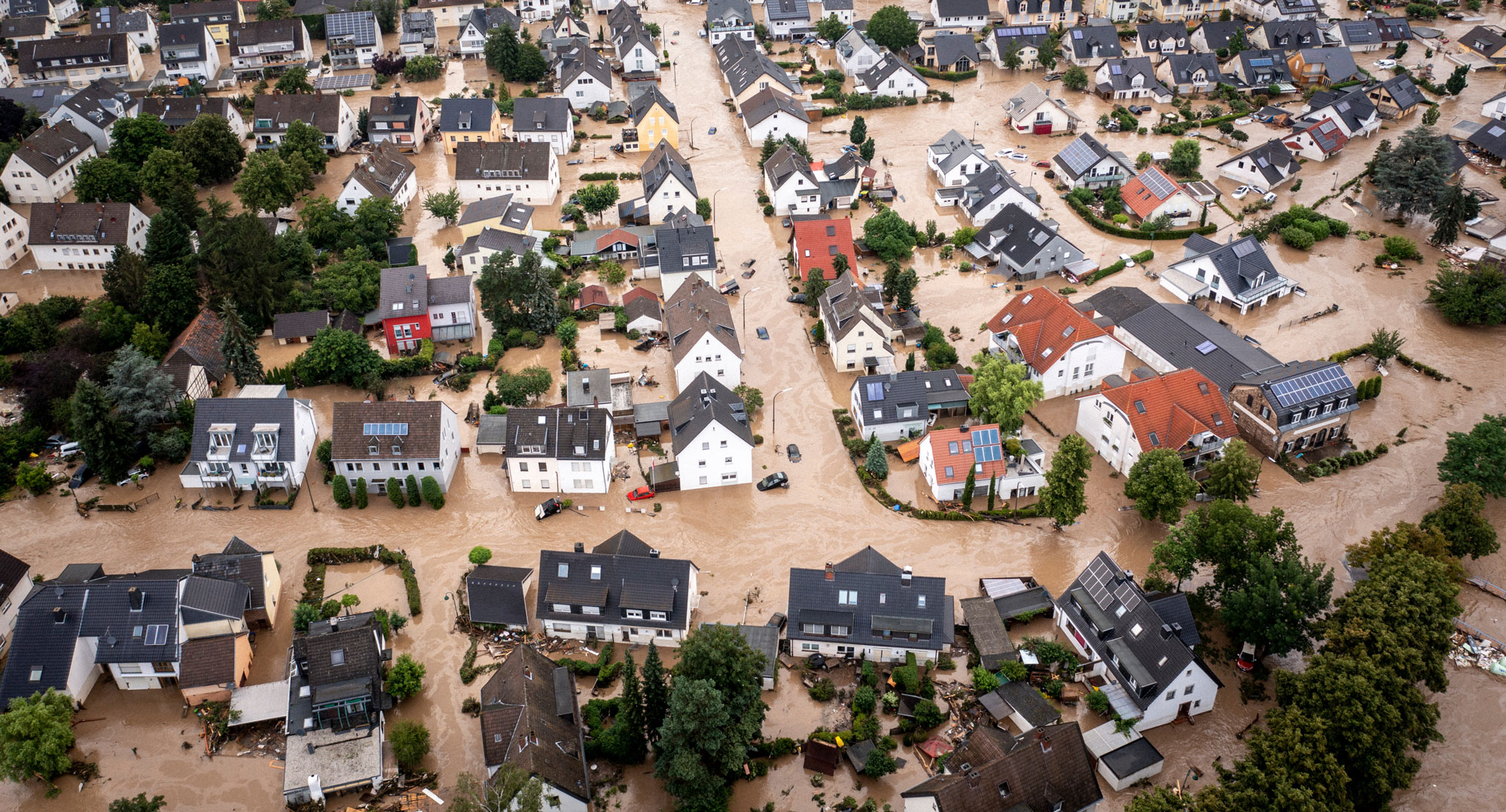 Luftbildaufnahme der Hochwasserkatastrophe von 2021. Zu sehen sind ganze Straßenzüge mit Einfamilienhäusern, die von schlammigem Wasser umspült werden.