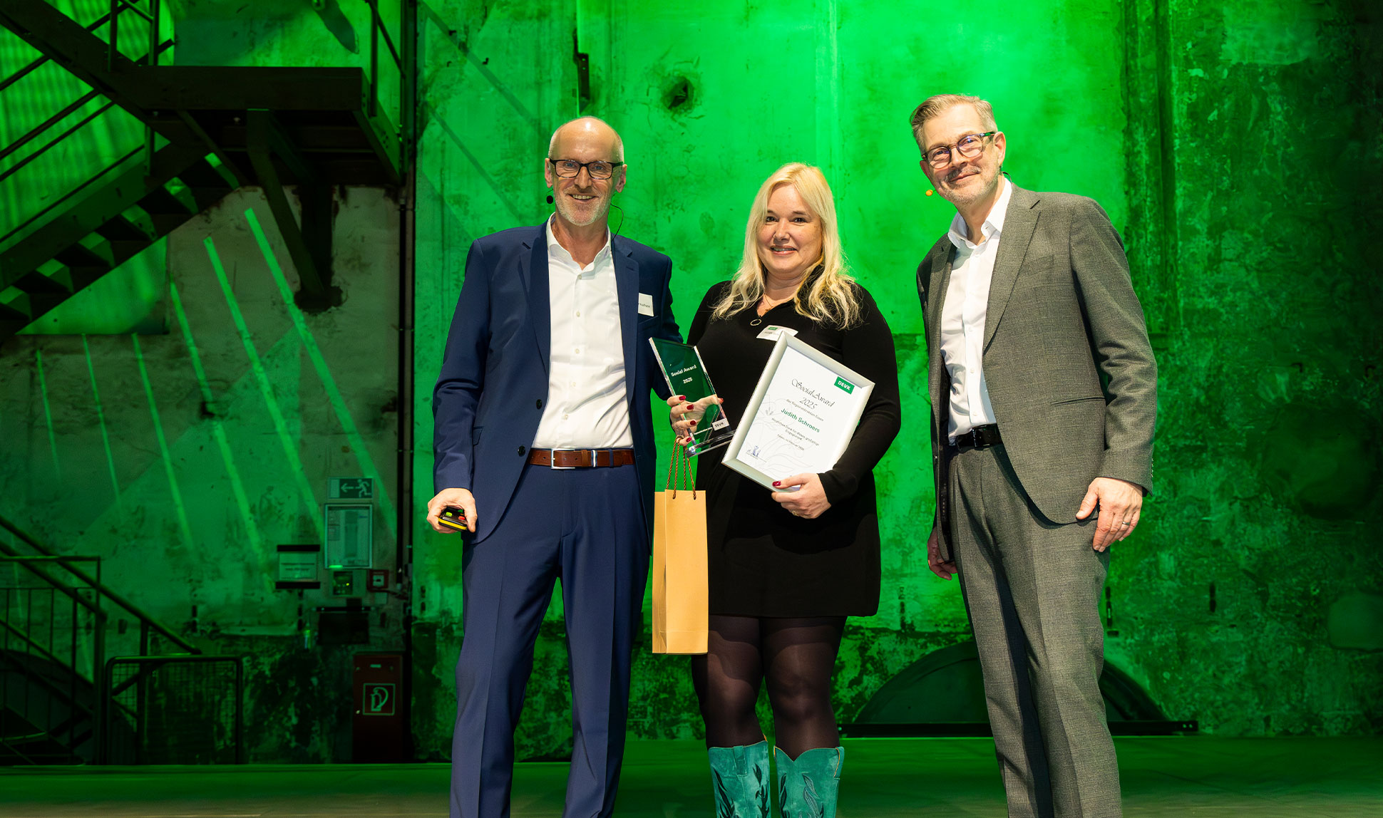 Judith Schroers wird auf der Jahresauftakttagung der DEVK Regionaldirektion Essen im Februar 2026 von Steffen Kaufmann, Geschäftsleiter Innendienst, und Axel Berberich, Geschäftsleiter Außendienst, mit dem Social Award geehrt. (v. l. n. r.: Steffen Kaufmann, Judith Schroers, Axel Berberich)