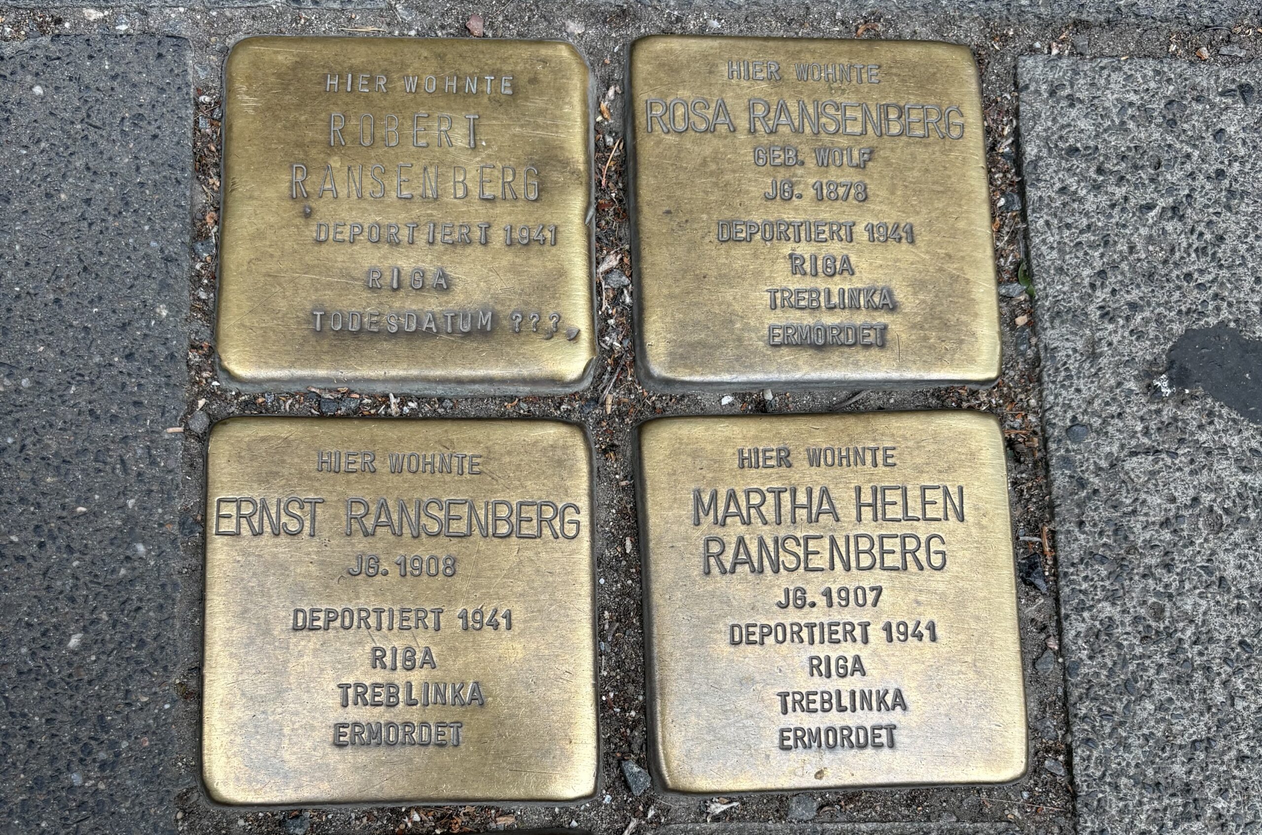 Vier verschmutze Stolpersteine in Köln für Robert, Rosa, Ernst und Martha Helen Ransenberg.