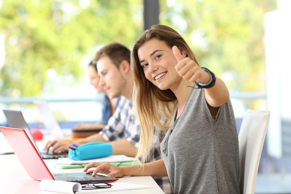 Studentin zeigt Daumen hoch und freut sich über ihren Studienplatz.